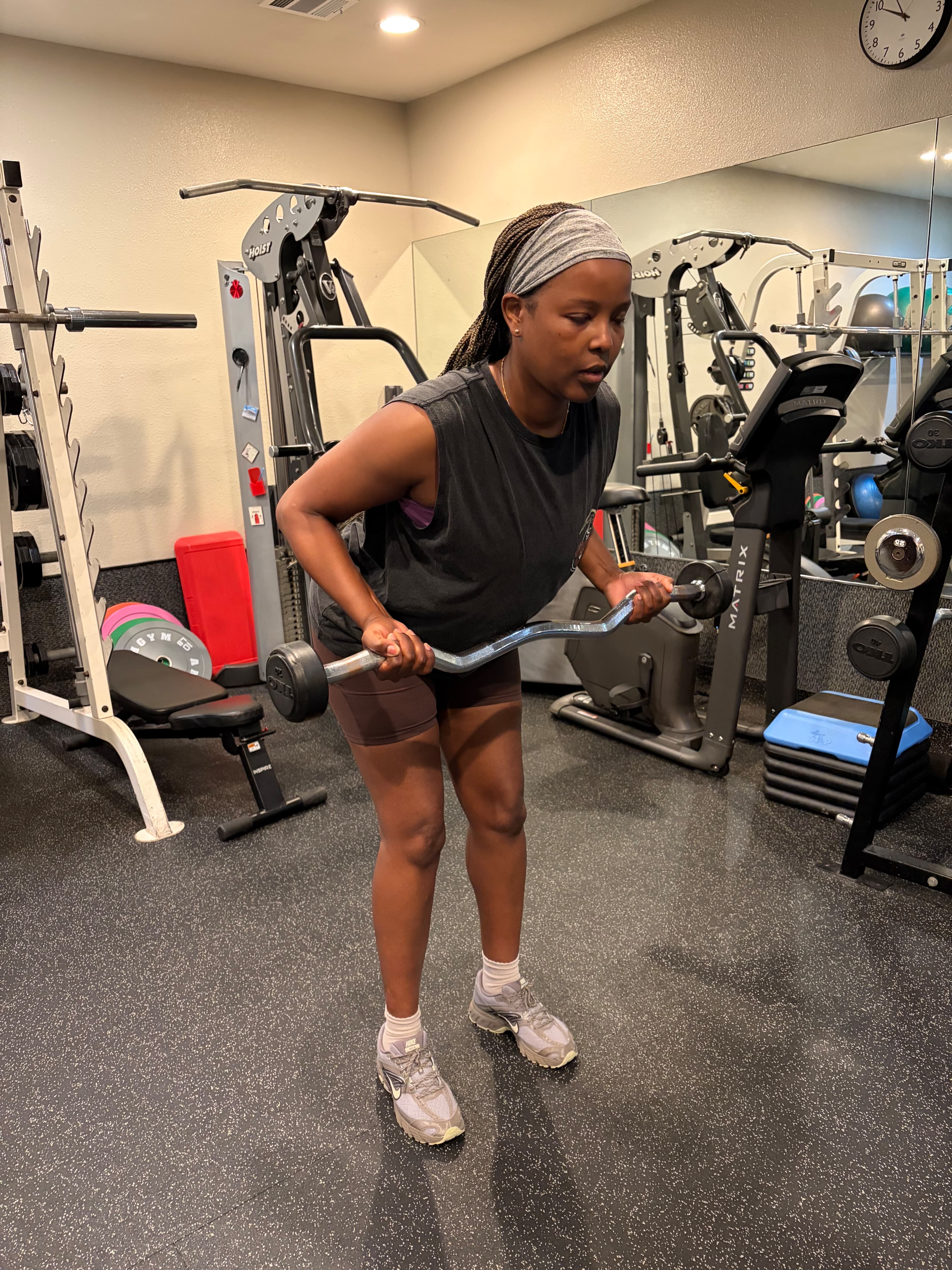 Client doing barbell curls in the private studio