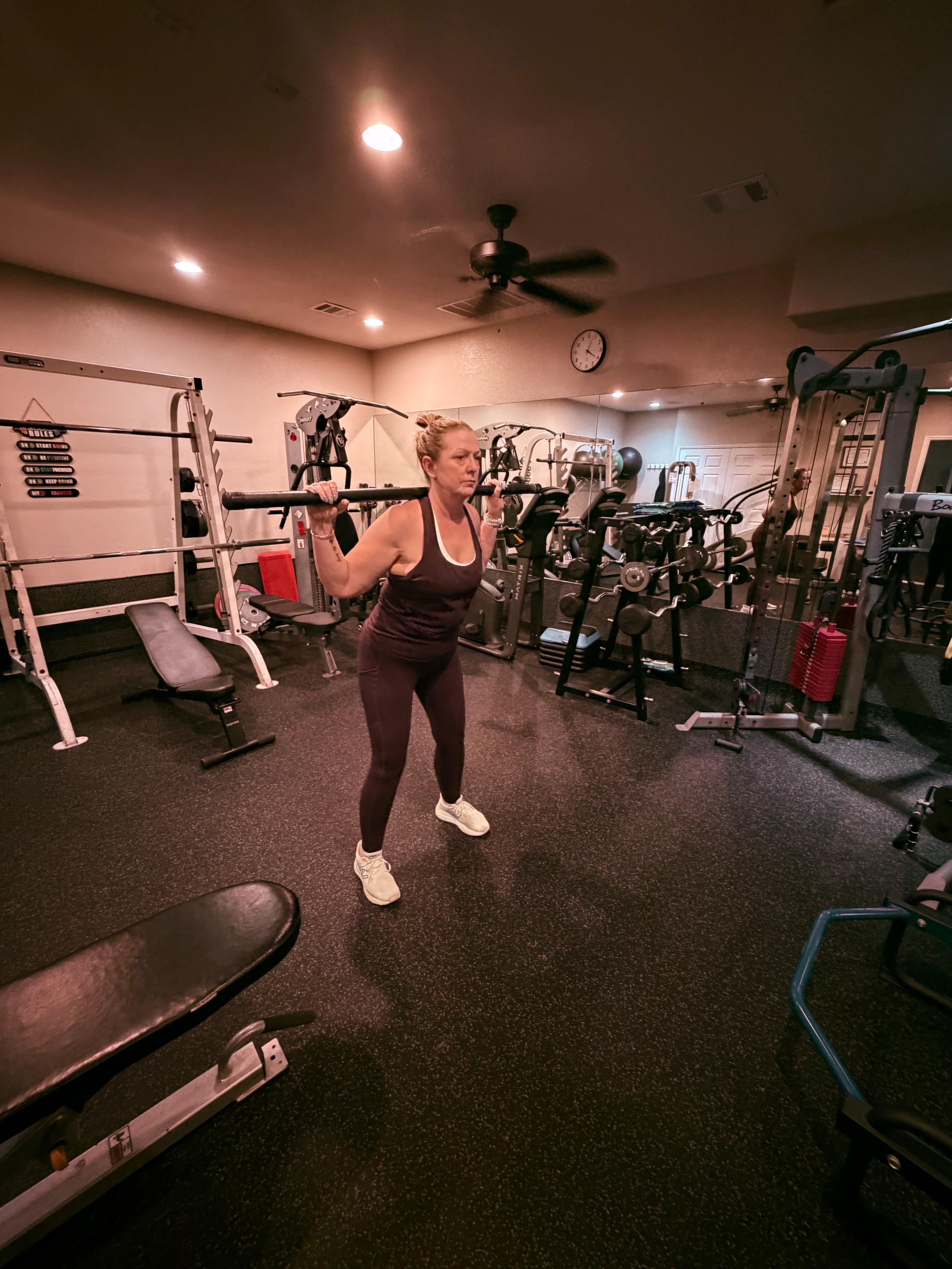 Client doing barbell squats in the studio