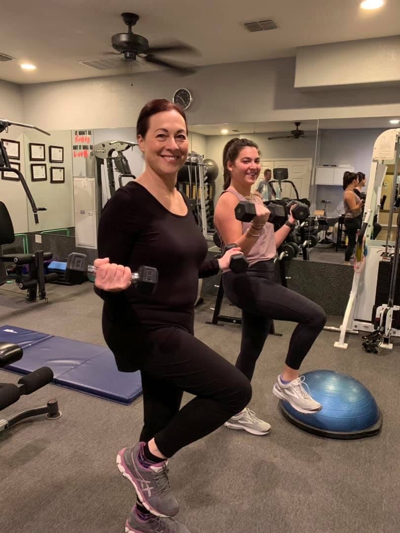 Frannie and client doing lunges with dumbbells in the studio