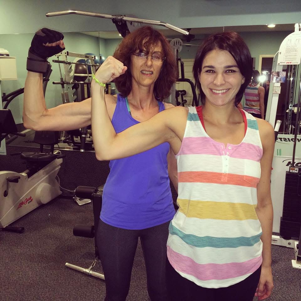 Frannie flexing with a happy client in the gym
