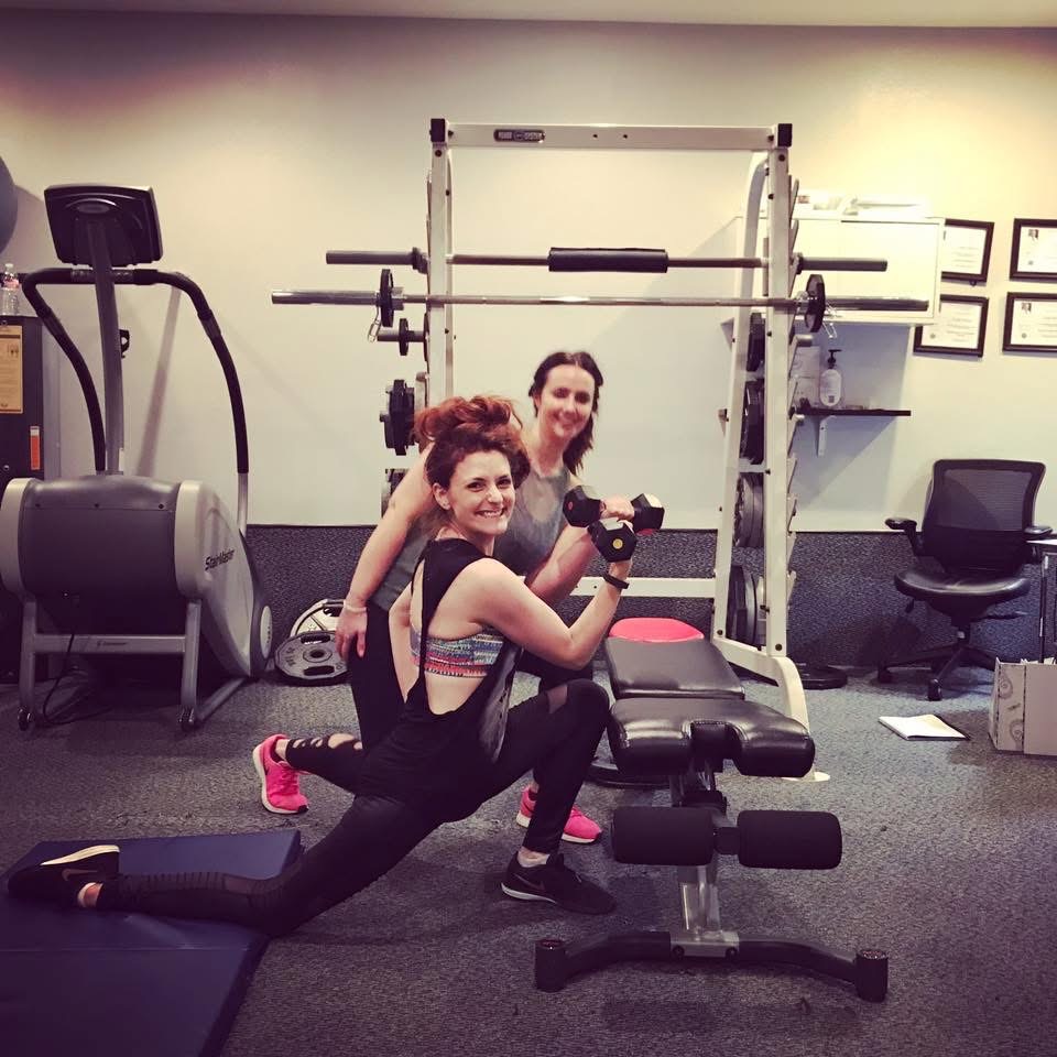 Client doing a lunge with dumbbell while Frannie coaches